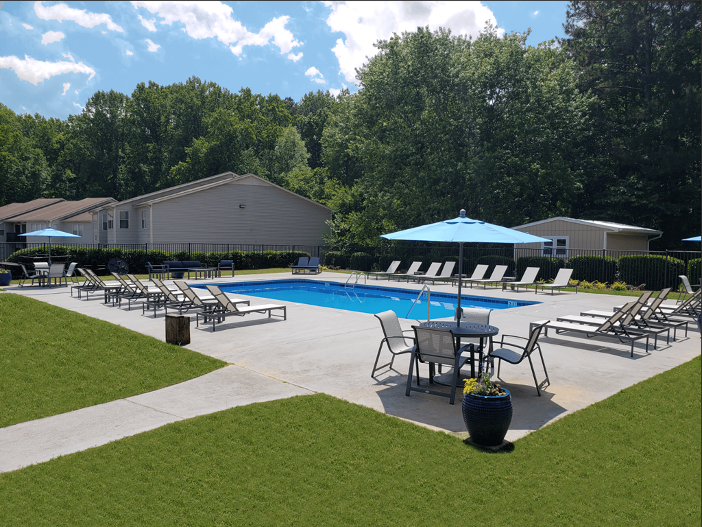 a swimming pool with chairs and tables and umbrellas
