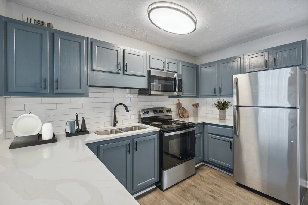 A kitchen with a stove top oven and a refrigerator.