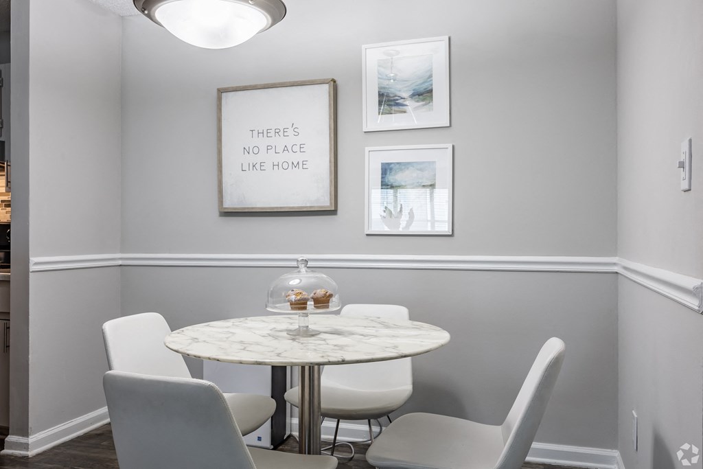a dining room with a marble table and white chairs