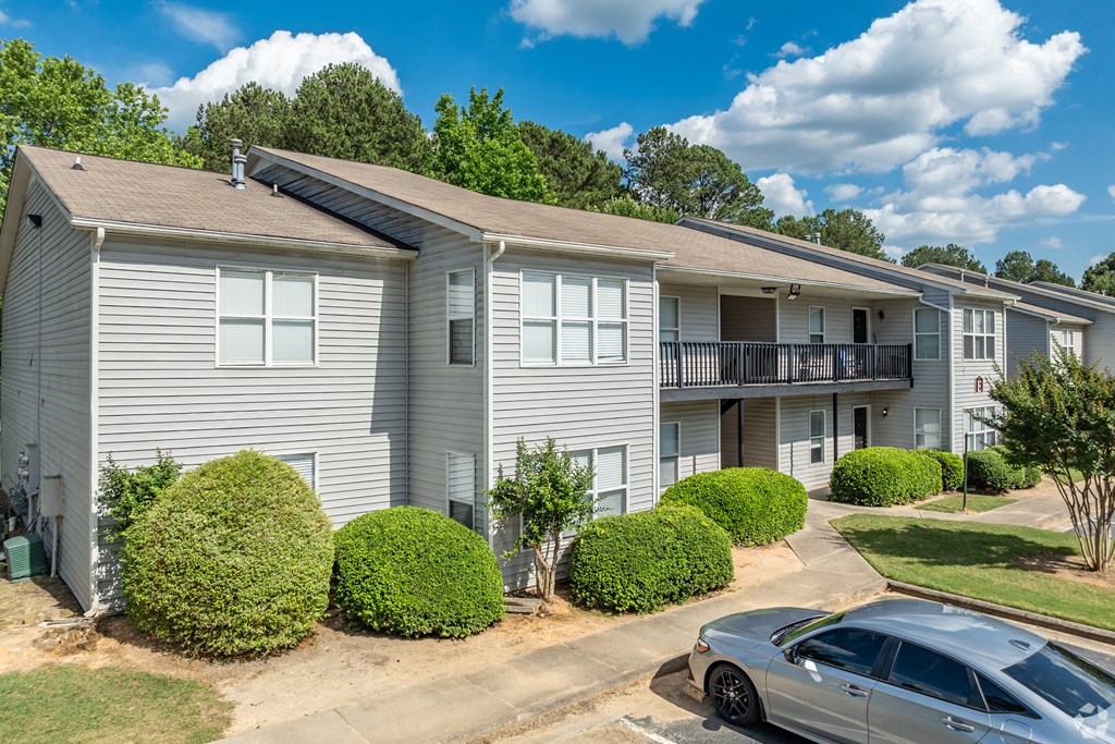 a white apartment building with cars parked in front of it