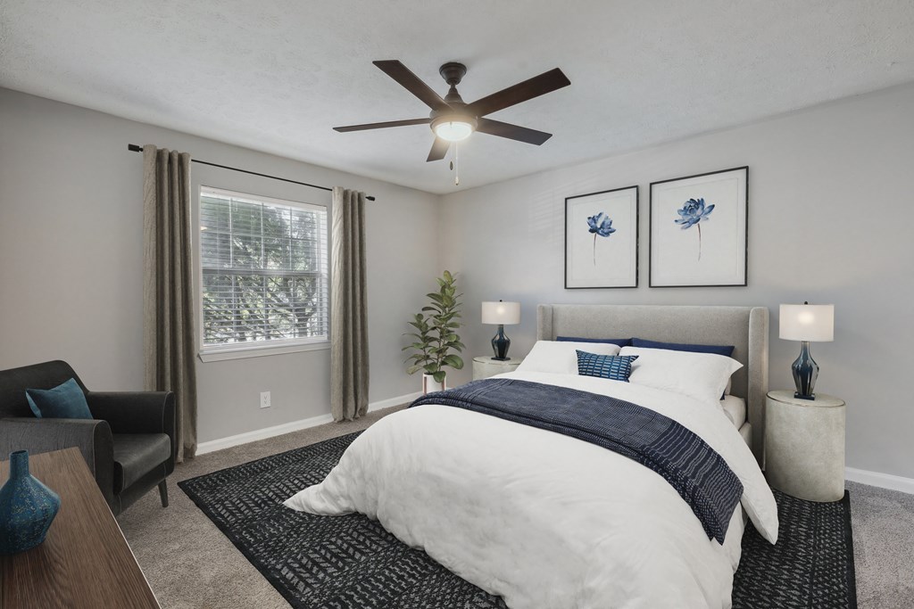 A bedroom with a large bed and a ceiling fan.