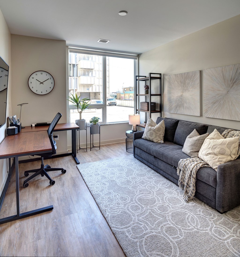 Kalamazoo, MI Apartments - Open-Floor Living Room With High Ceilings, Wood-Inspired Plank Flooring, And An Expansive Window With Roller Shades