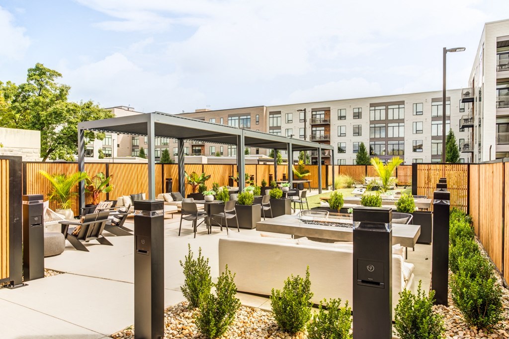 a patio with tables and chairs and a building in the background