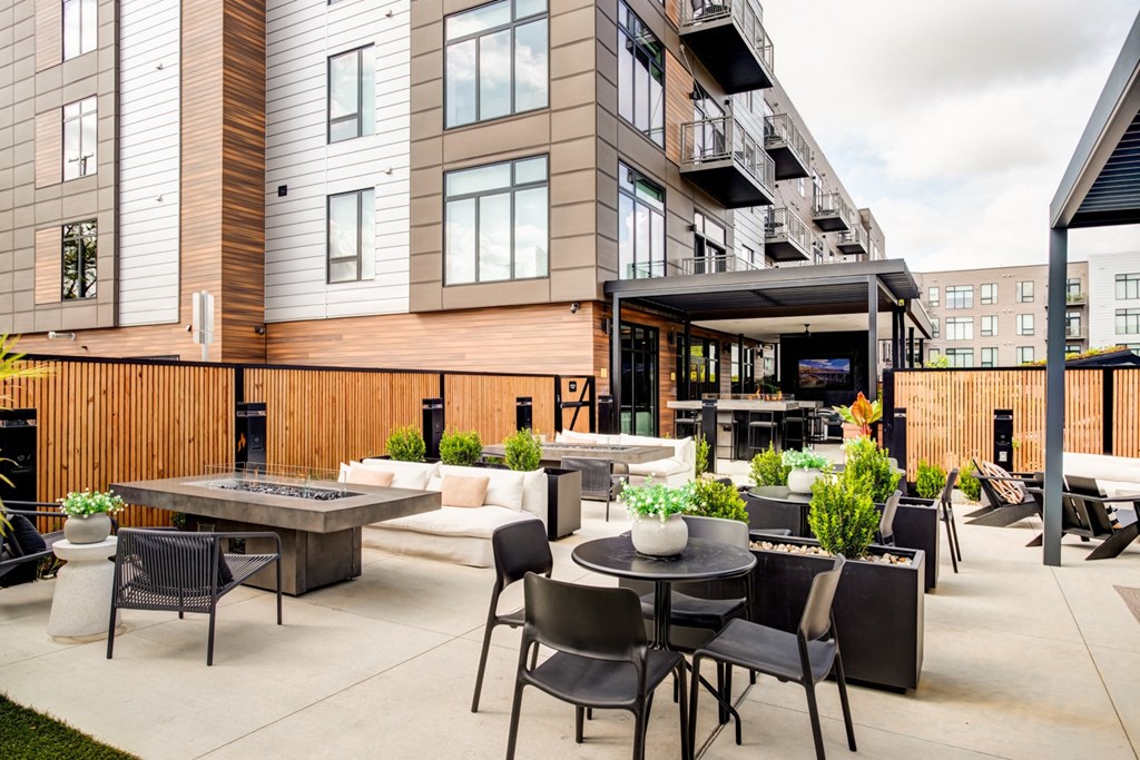 a patio with tables and chairs outside of a building