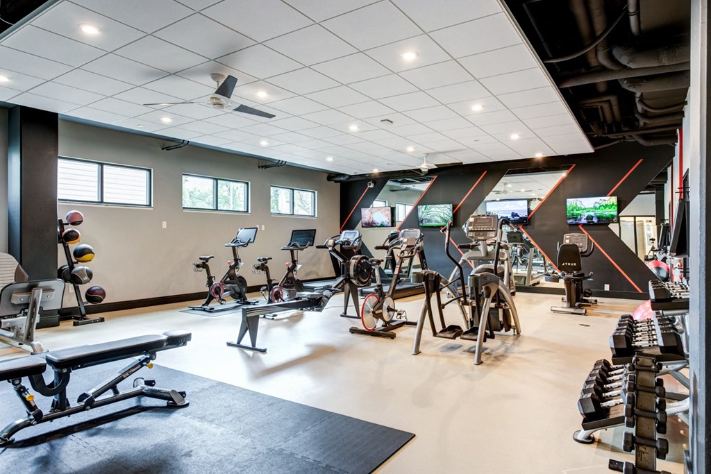 a gym with a variety of exercise machines and weights