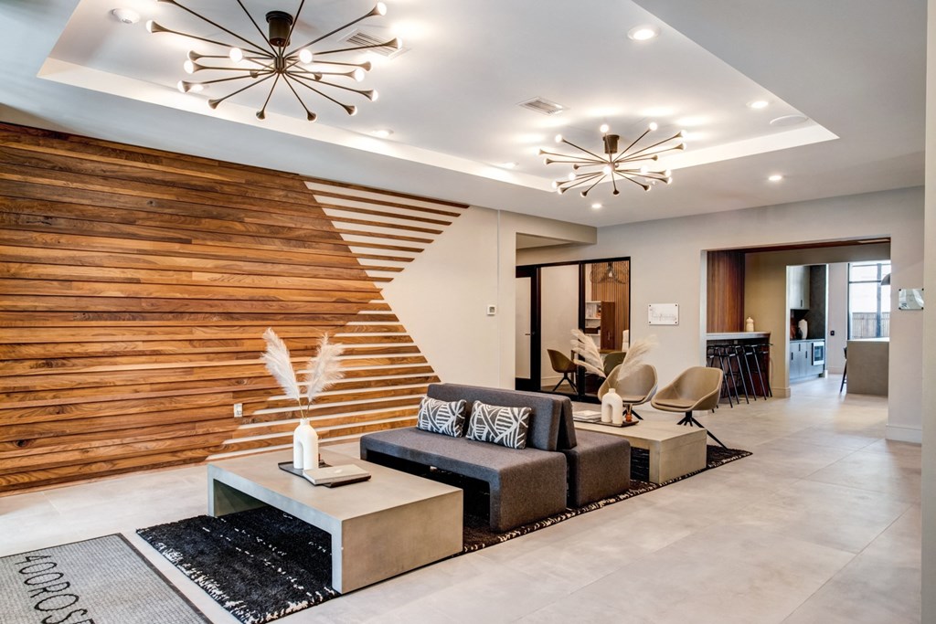 a living room with a wooden accent wall and two modern lights