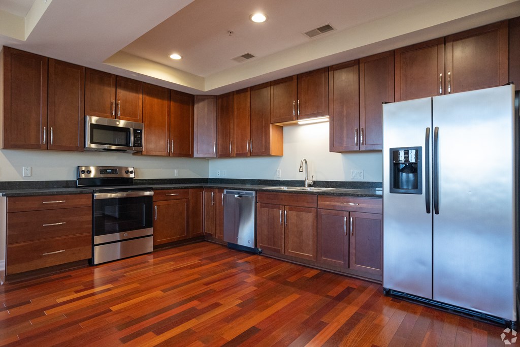 a large kitchen with wooden cabinets and stainless steel appliances