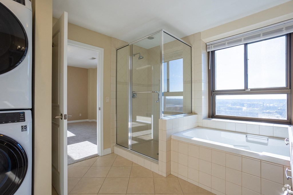 a bathroom with a tub and a shower and a washing machine
