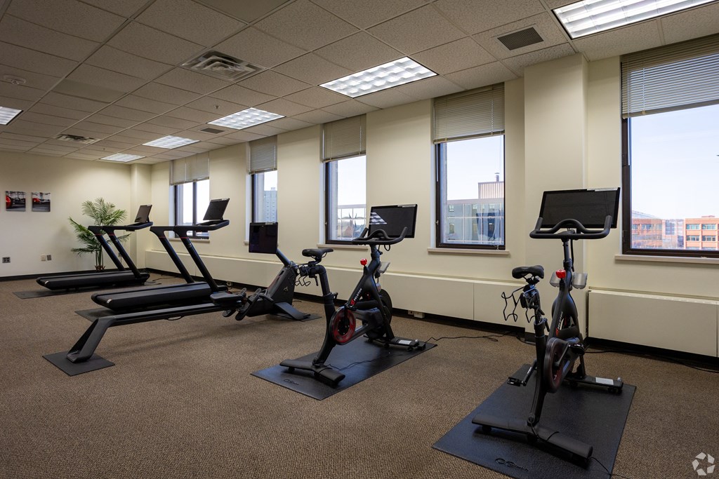 a group of exercise bikes in a room with windows