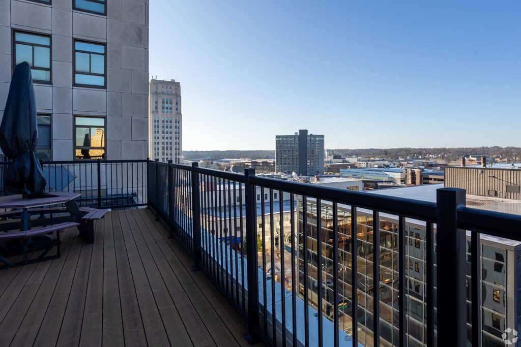 a balcony with a view of a city and a pool