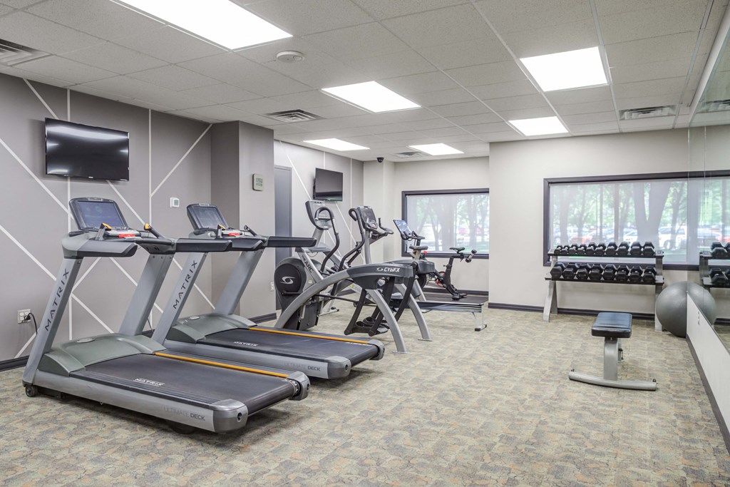a gym with treadmills and other exercise equipment and a television
