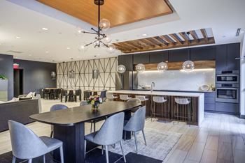 a large dining room with a table and chairs and a kitchen