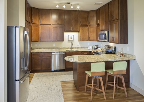 A kitchen with wooden cabinets and a granite countertop.