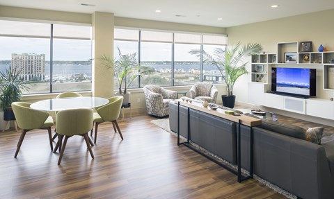 A living room with a large window overlooking the water.