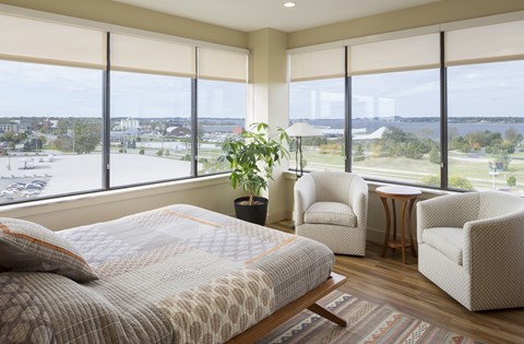 A bedroom with a large bed and a view of the city.