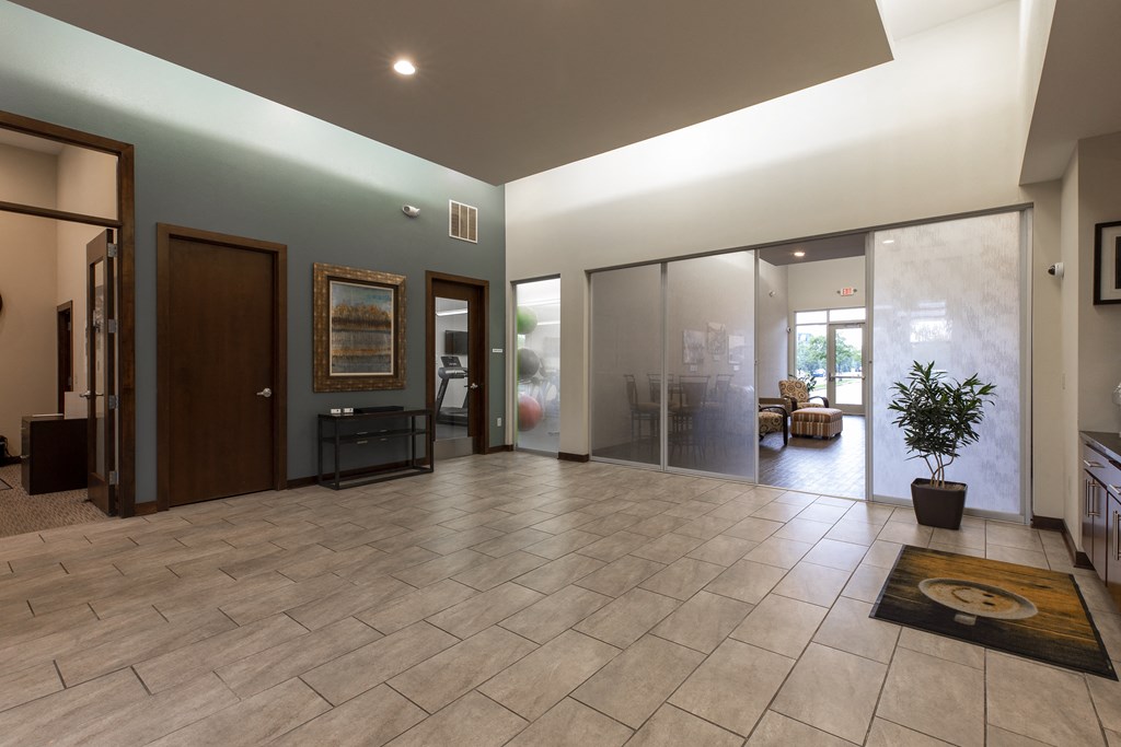 a large living room with a tiled floor and a large door way