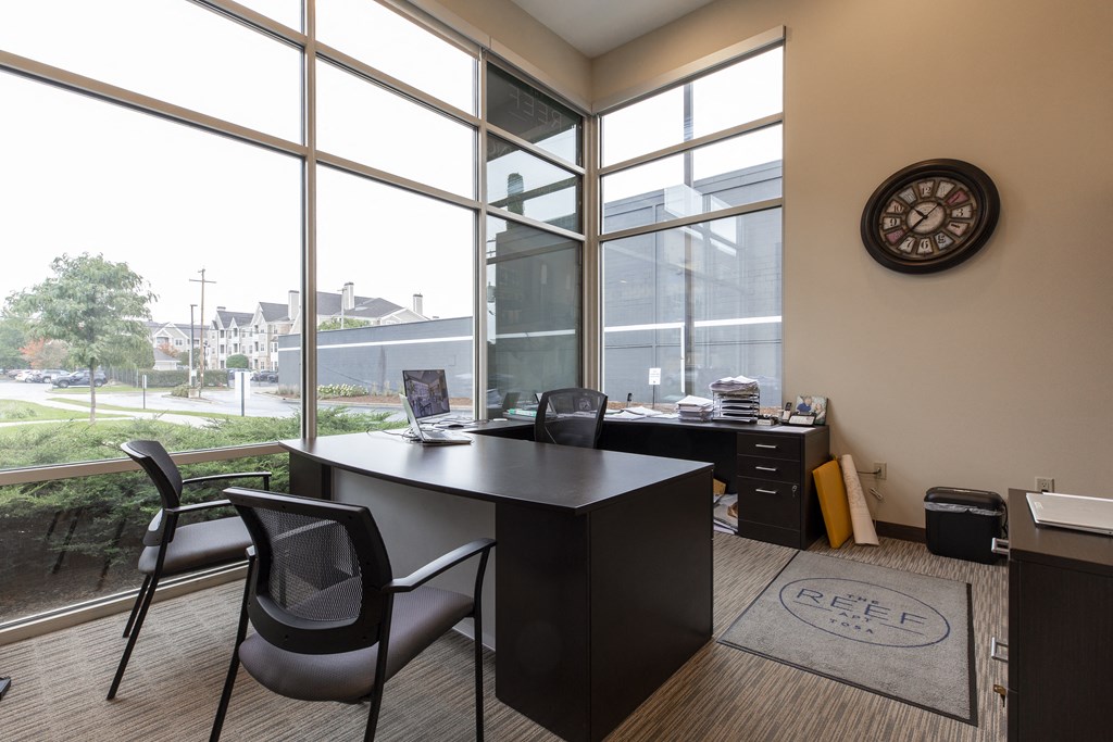 an office with a desk and a clock on the wall