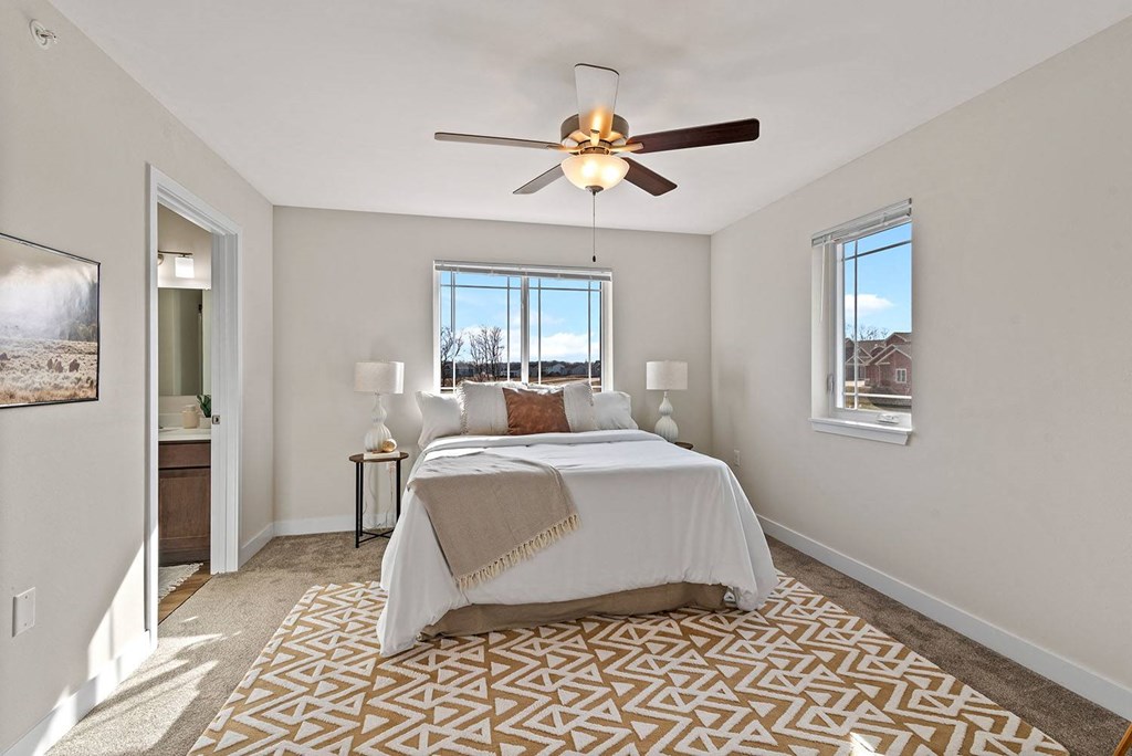 a bedroom with a bed and a ceiling fan at The Residences Apartments at Bear Tree, DeForest, Wisconsin