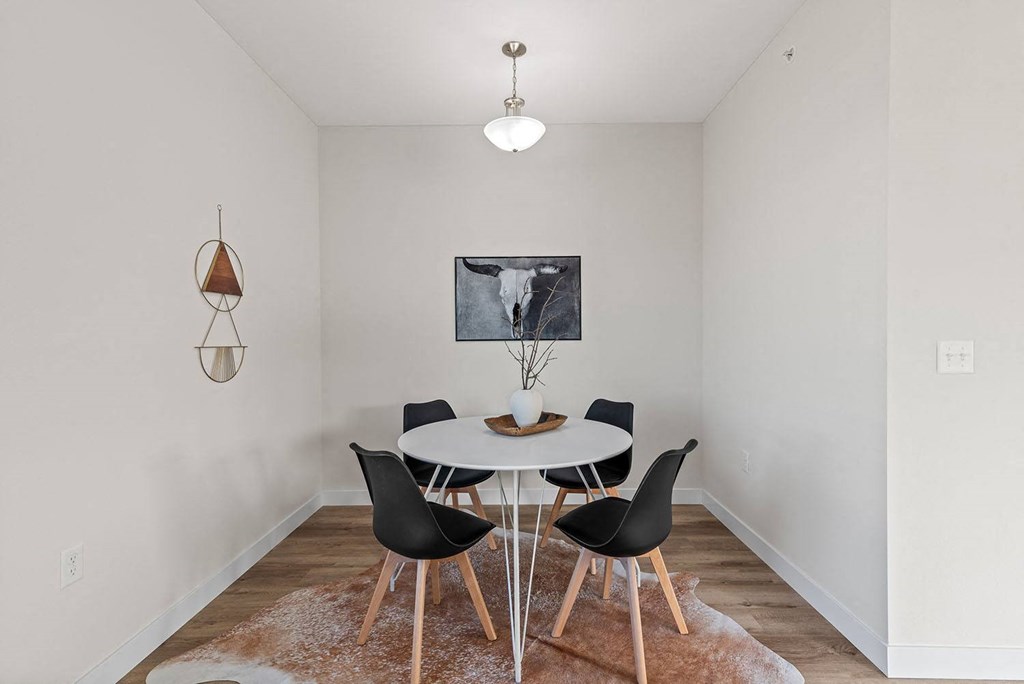 a dining room with a white table and chairs at The Residences Apartments at Bear Tree, DeForest, WI, 53532
