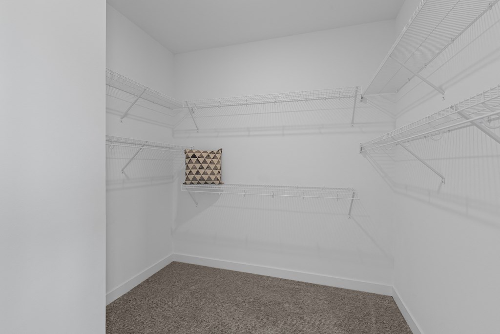 a room with white walls and a white closet with shelves and a window in it at Tivoli Green Apartments & Townhomes, Mount Pleasant, WI