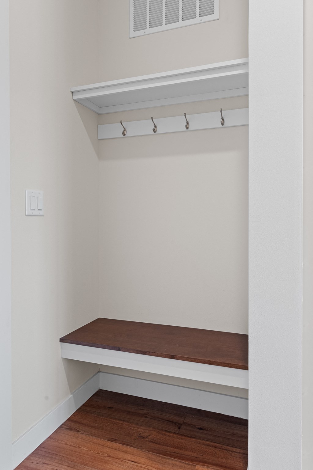 a small room with a wooden bench and a white wall at Tivoli Green Apartments & Townhomes, Mount Pleasant, WI