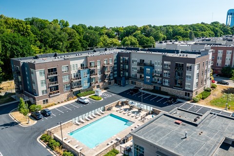 A large apartment complex with a pool and a parking lot.