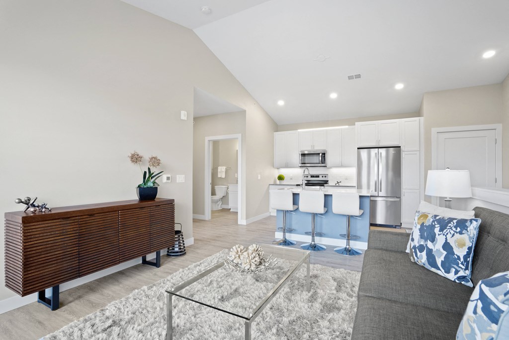 a living room with a couch and a table with a kitchen in the background