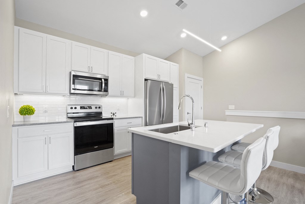 a kitchen with white cabinets and stainless steel appliances