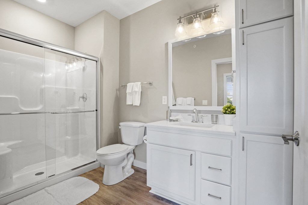 a white bathroom with a shower toilet and sink