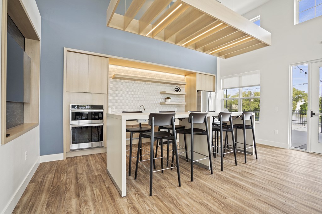 a kitchen with a bar and stools in front of a kitchen island with a