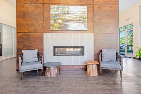 A living room with a fireplace and two chairs.