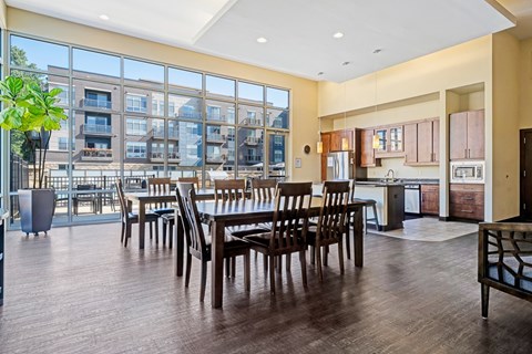 A large dining room with a view of apartment buildings outside the large windows.