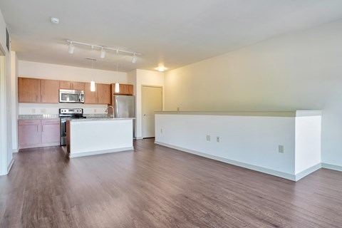 A kitchen with a white counter and wooden floors.