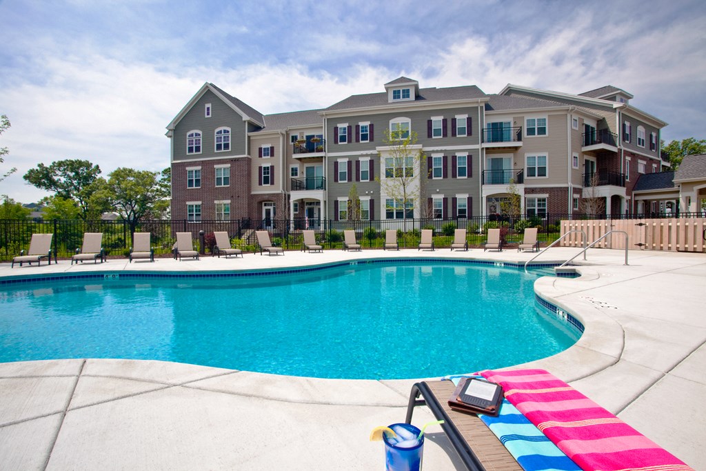 an outdoor swimming pool with an apartment building in the background