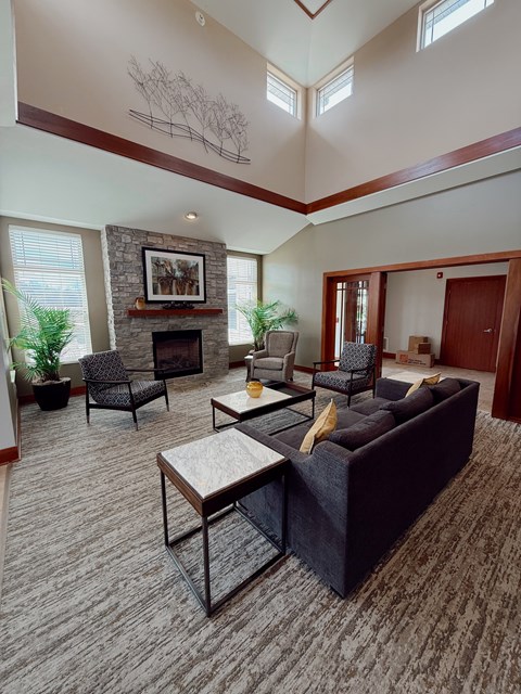 A living room with a stone fireplace and a painting above it.