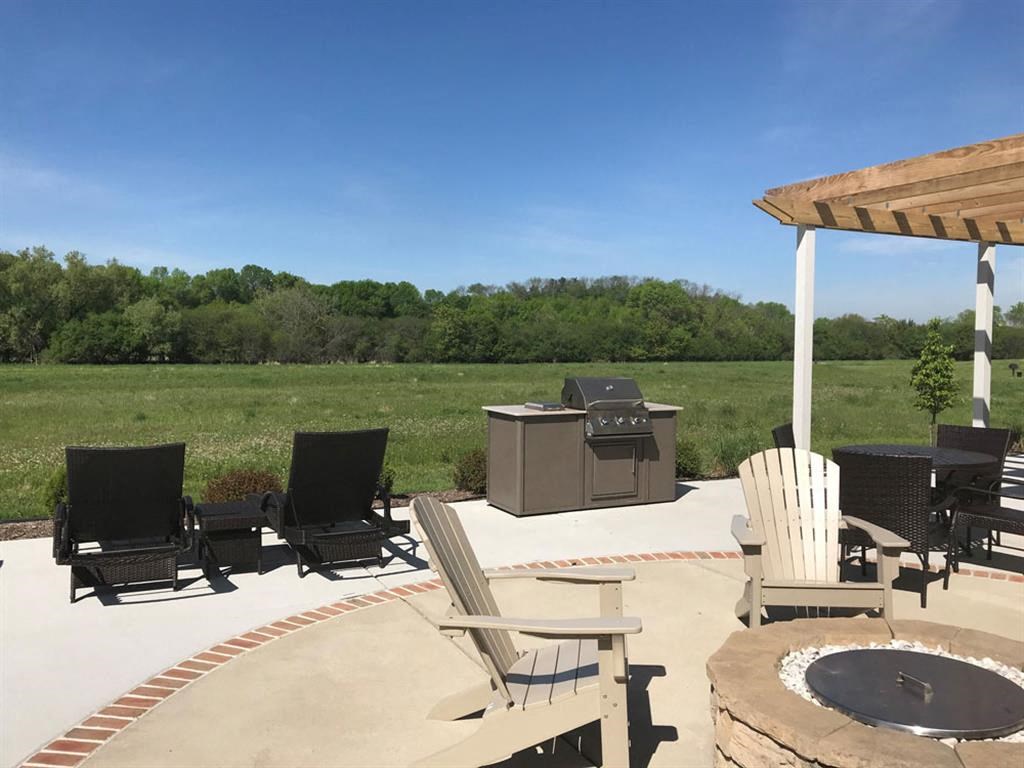 a patio with chairs and a fire pit