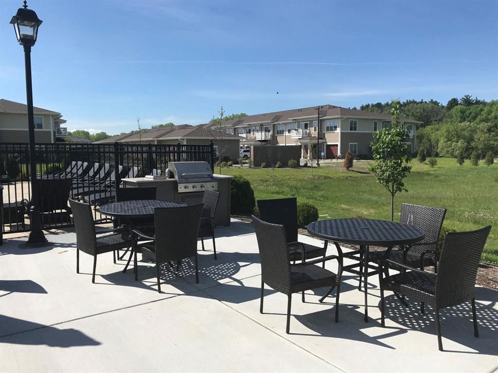 the patio of the building has tables and chairs and a grill