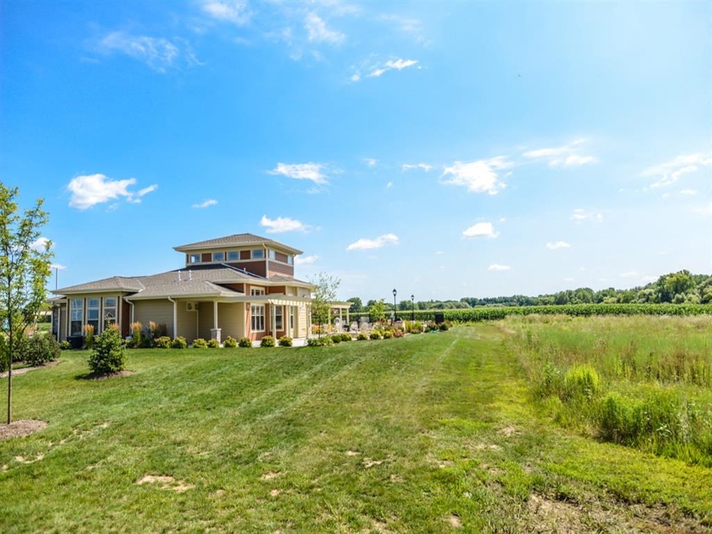 a house in the middle of a field with a grassy field