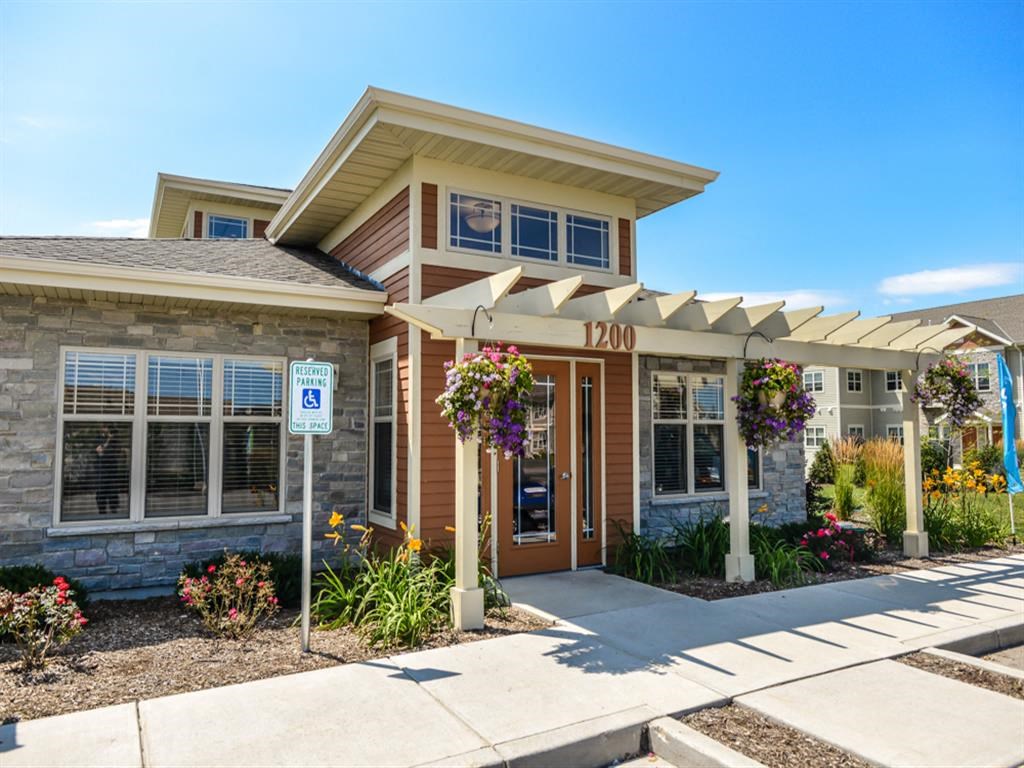 the front of a house with a sidewalk and a parking meter