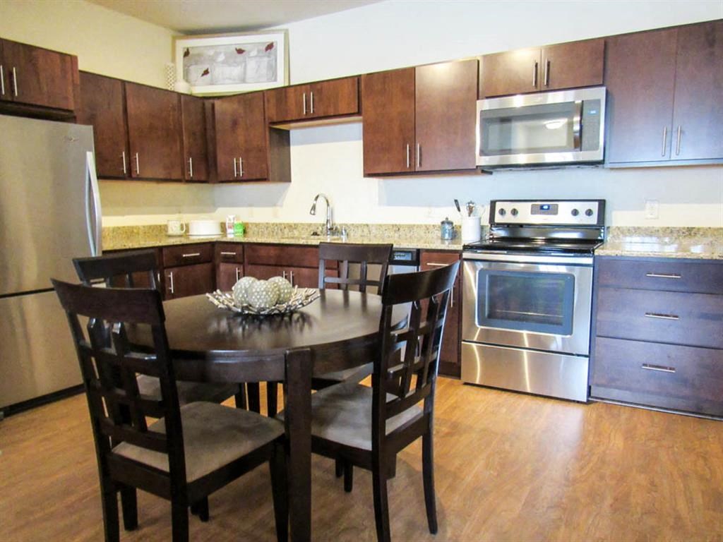 a kitchen with stainless steel appliances and a wooden table