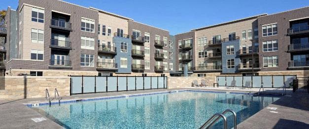 a large swimming pool in front of an apartment building
