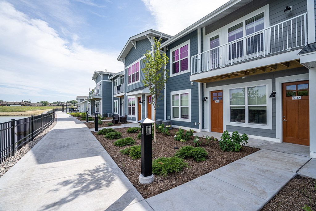 a row of townhomes with a sidewalk in front of them