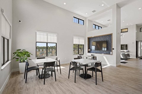 A modern dining room with a large table and chairs.