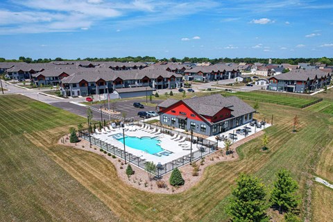 A large swimming pool surrounded by a fence in a grassy area.