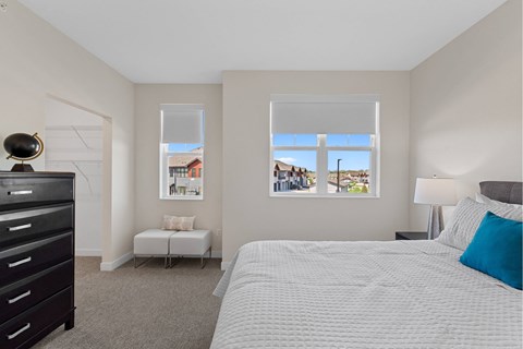 A bedroom with a large bed, a window with a view, and a dresser.