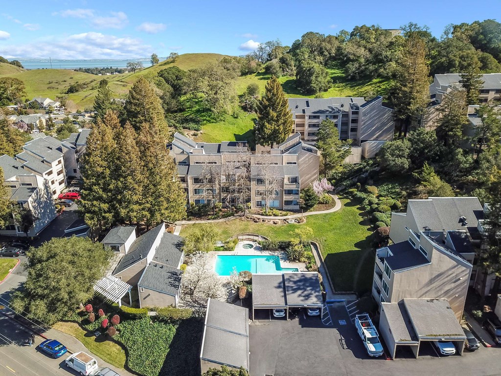 aerial view of buildings, lawn, and pool