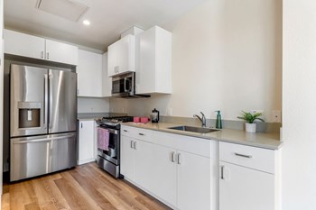 kitchen view with stove, microwave, fridge, and sink - Photo Gallery 2