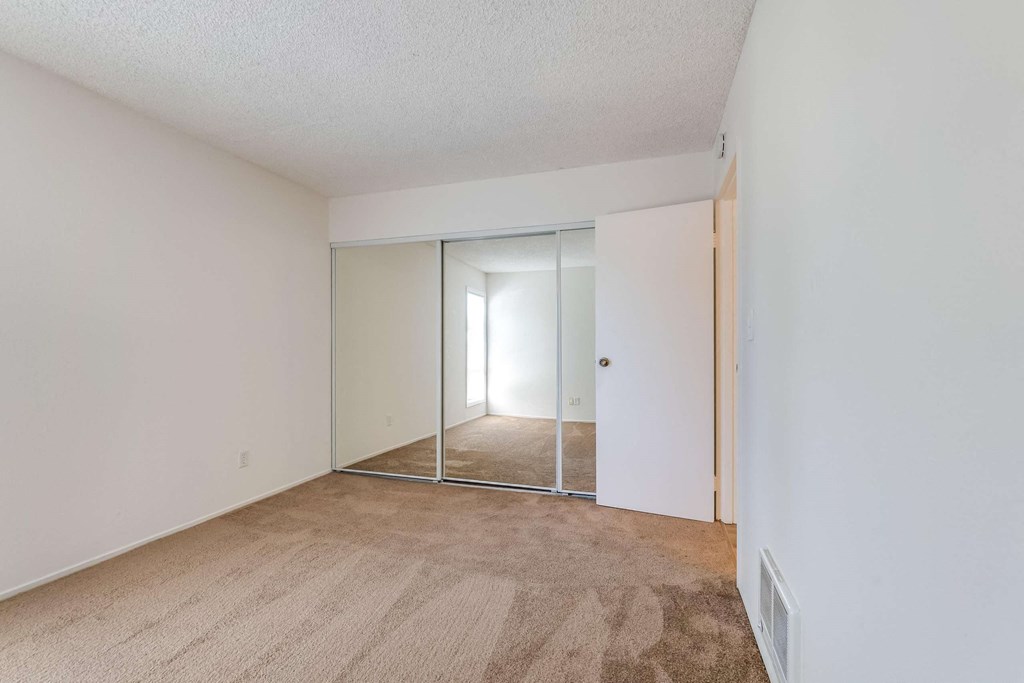 bedroom with mirrored closet doors