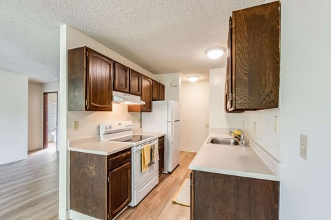 a kitchen with white appliances and wooden cabinets