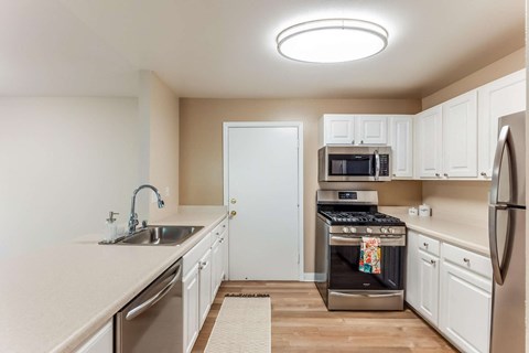 a kitchen with white cabinets and stainless steel appliances